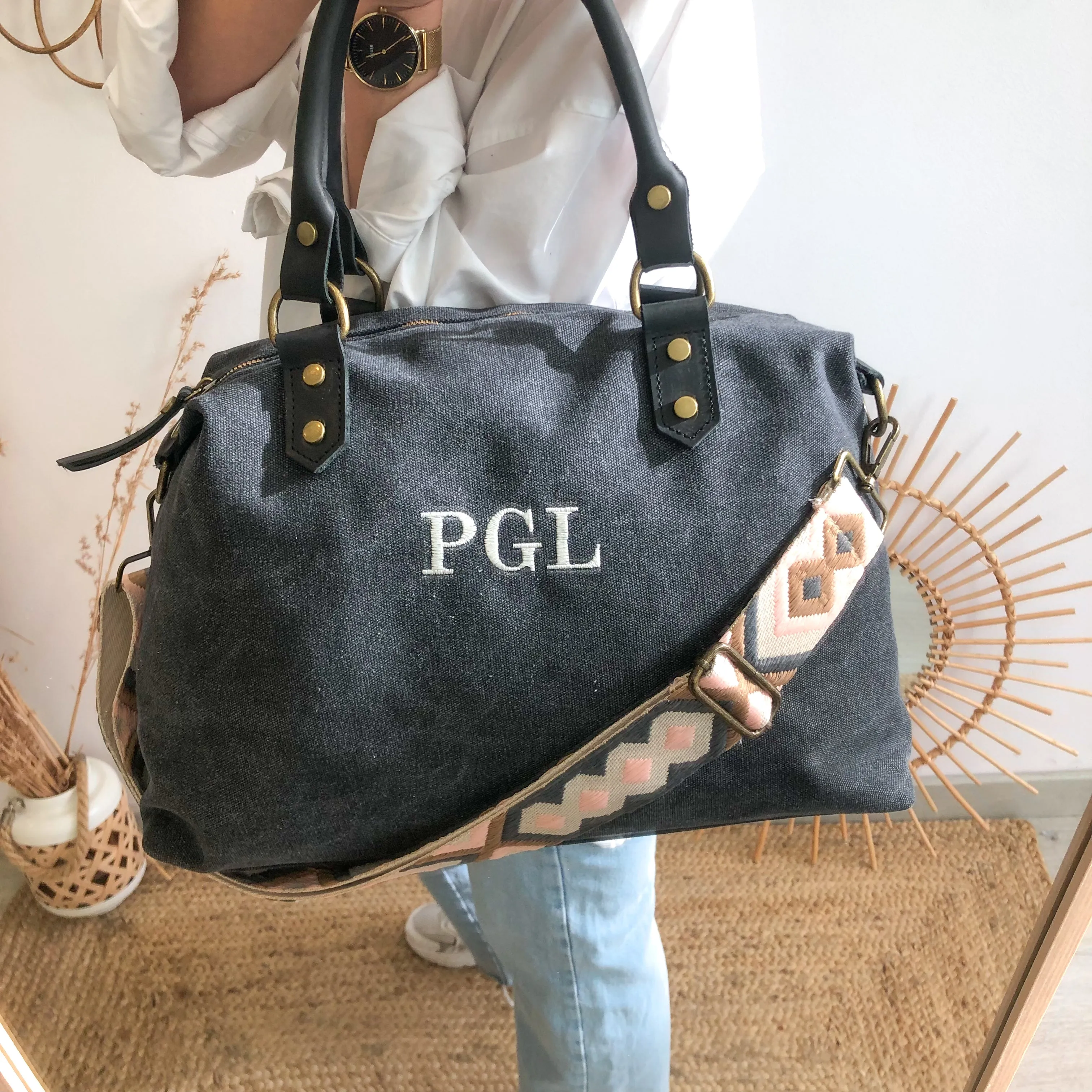 Bolso combinado loneta y piel negro iniciales bordadas con correa étnica