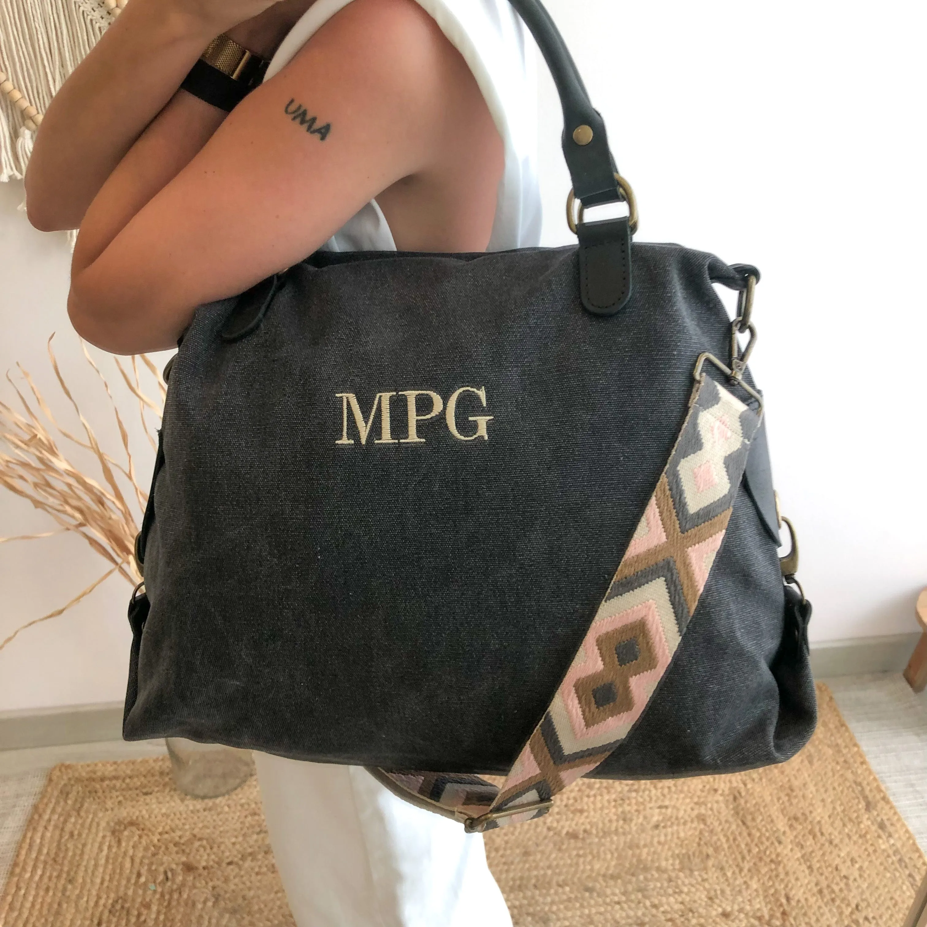 Bolso loneta y piel negro gastado iniciales bordadas con correa étnica
