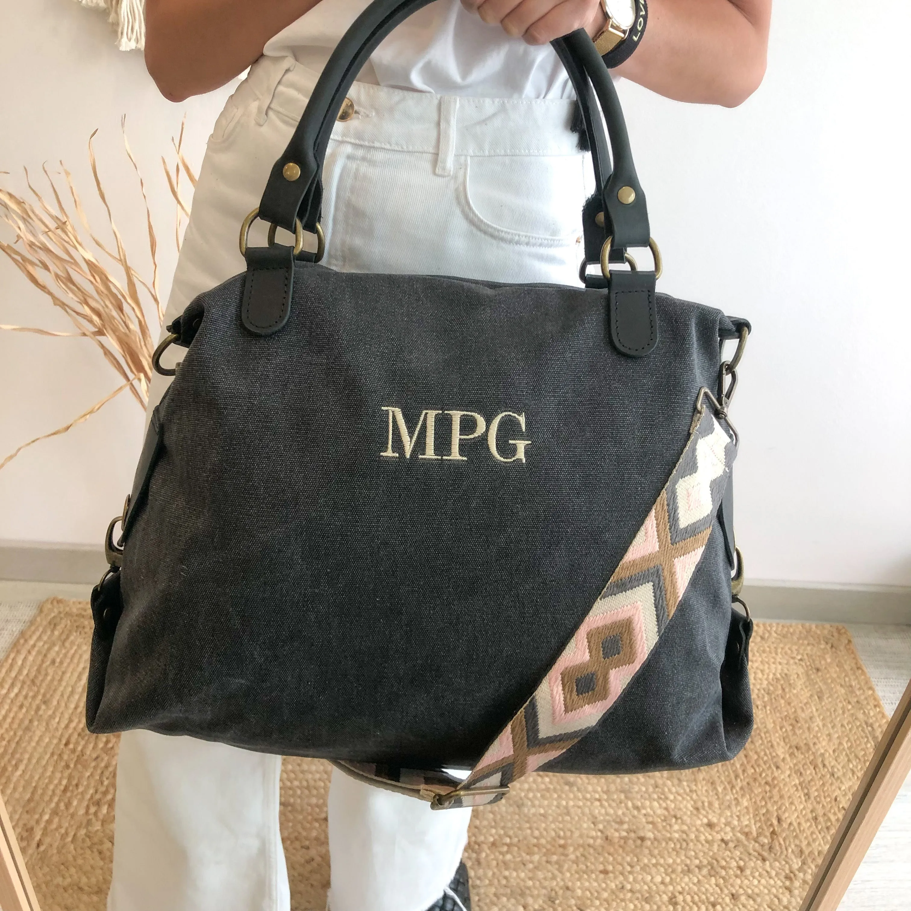Bolso loneta y piel negro gastado iniciales bordadas con correa étnica