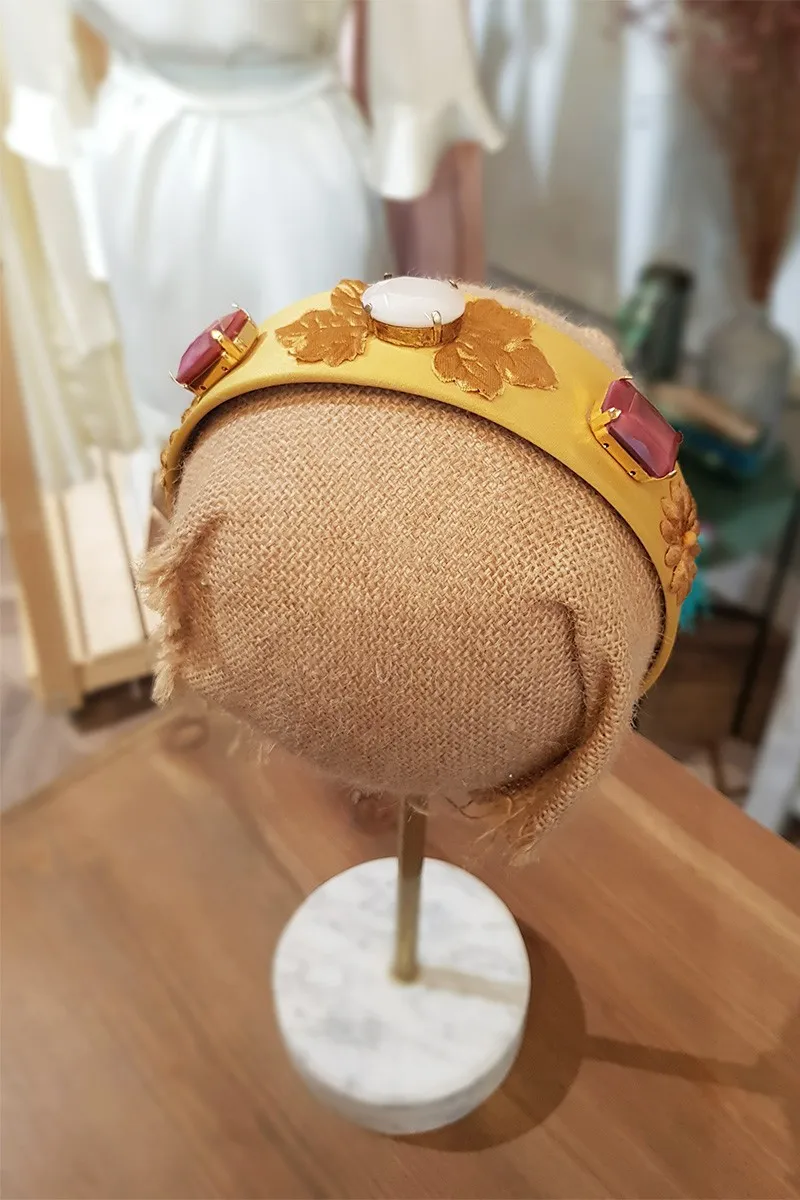 Diadema dorada con hojas y piedras facetadas blancas y frambuesas